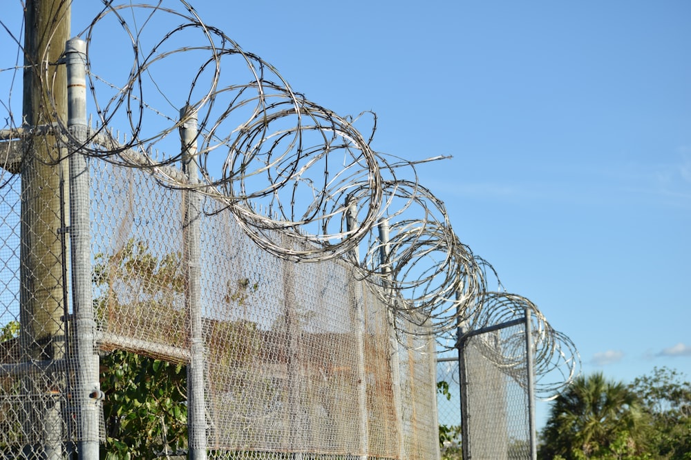 a fence that has a bunch of barbed wire on top of it