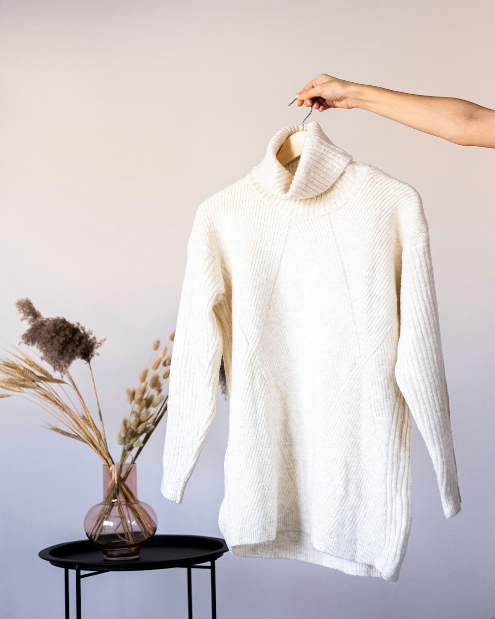 a white sweater hanging on a clothes rack