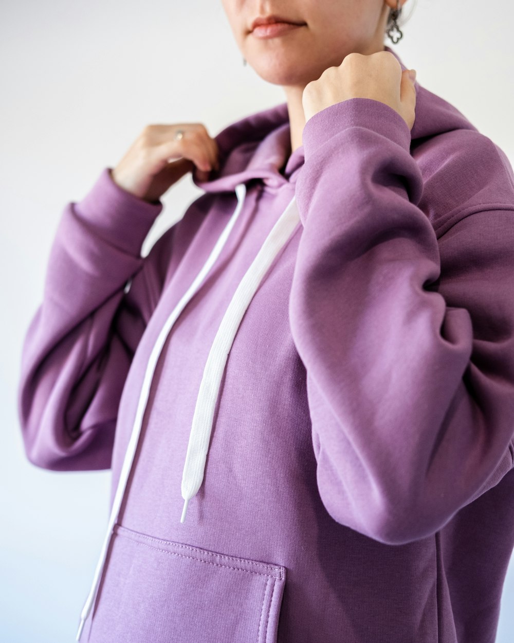 a woman in a purple hoodie poses for a picture