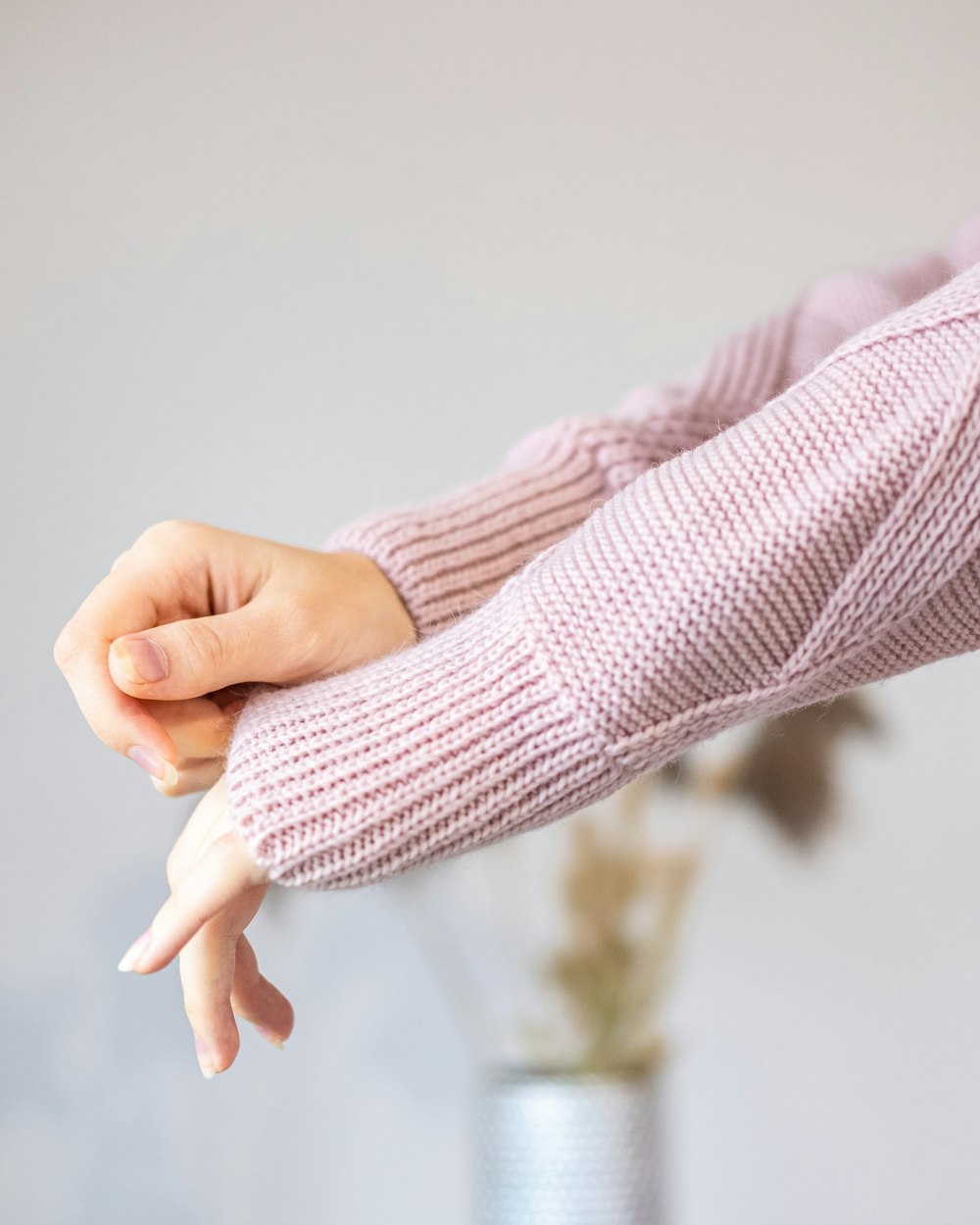 a woman in a pink sweater holding her hand out