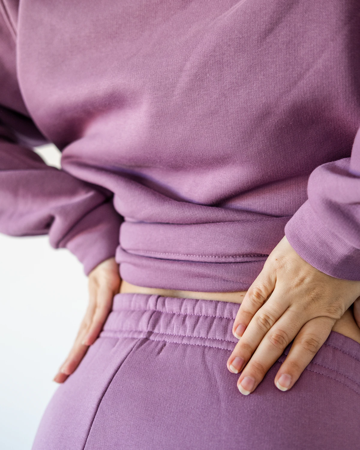 Person with their hands on their hips showing the location of gluteal tendinopathy pain over the outer hip bone that flares up lying on the side at night