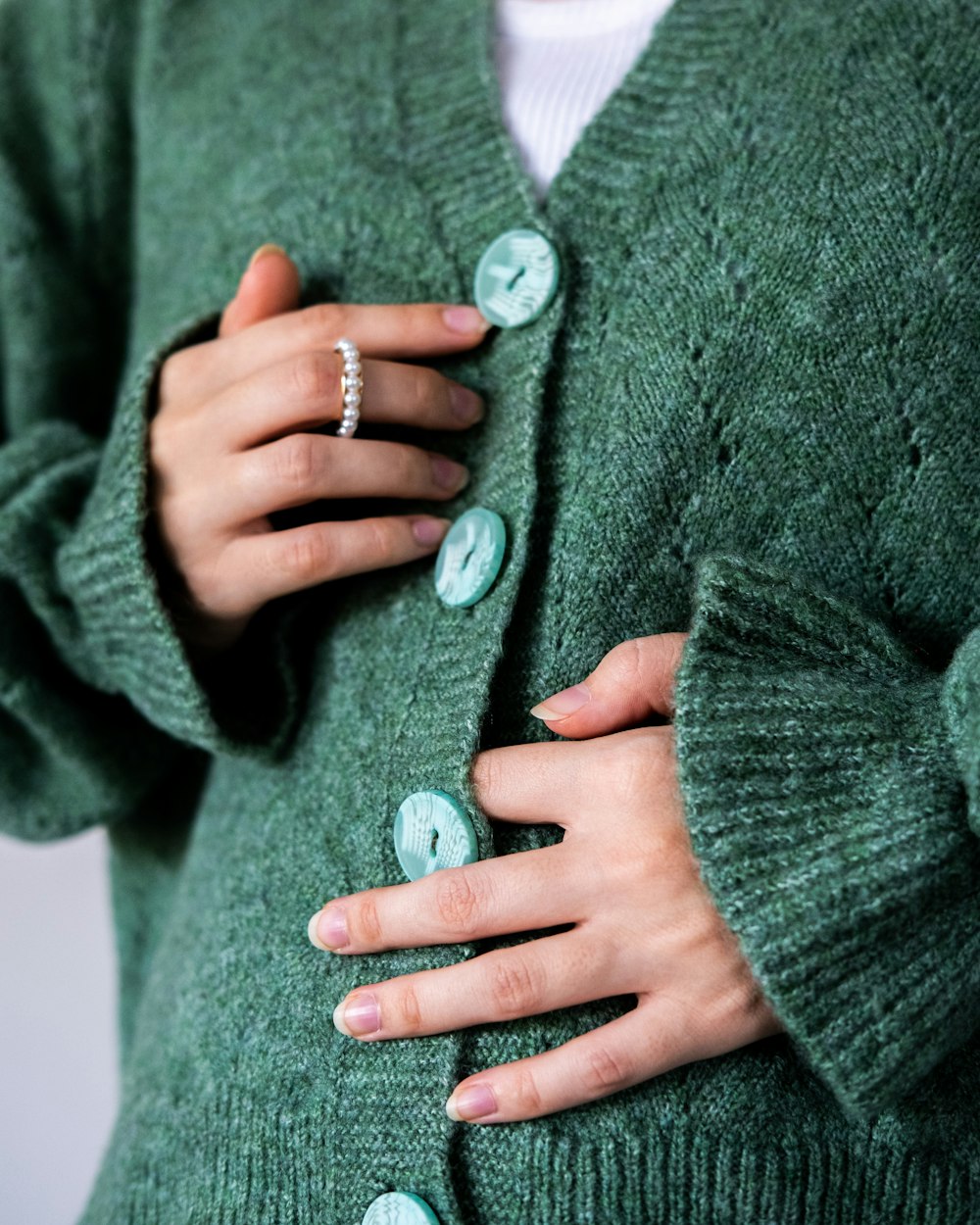 a woman wearing a green sweater with buttons on it