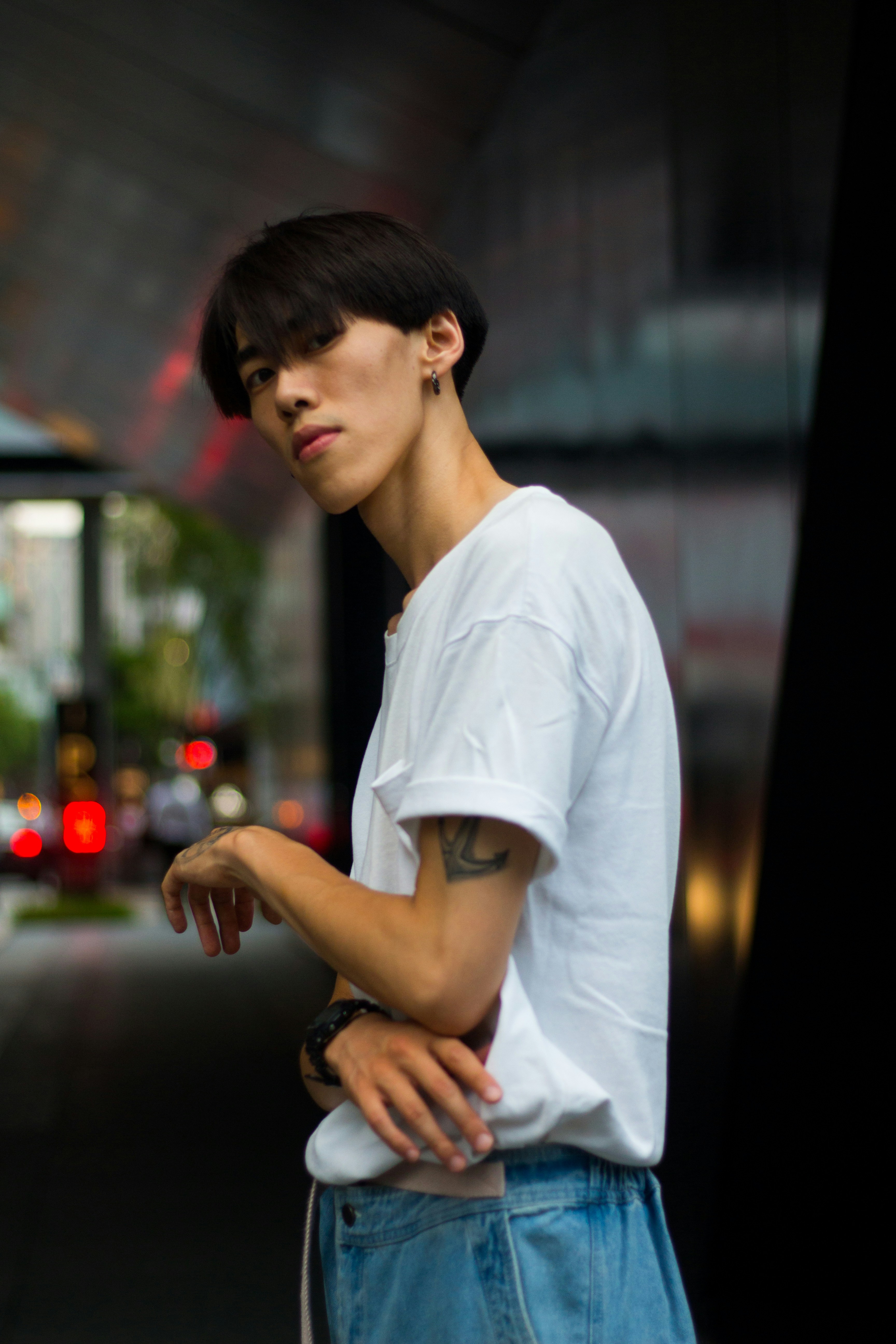 White oversized t-shirt worn by young person in urban setting, dim streetwear aesthetic