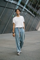 A casual urban street scene with a person walking in a jen jee oversized t-shirt.