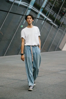 A model wearing a comfortable t-shirt and trousers set, walking casually in an urban setting.