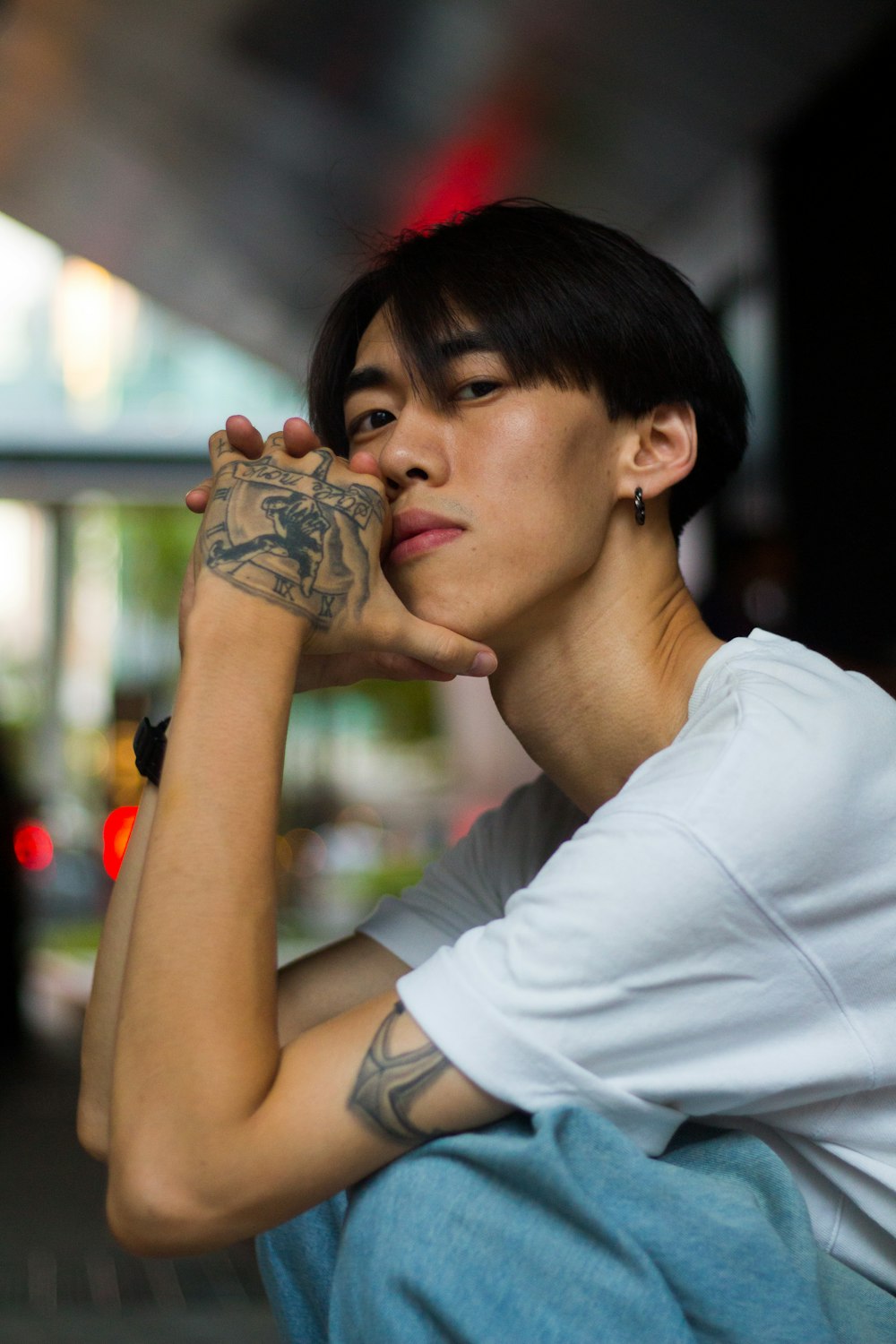 a man with tattoos sitting on a bench