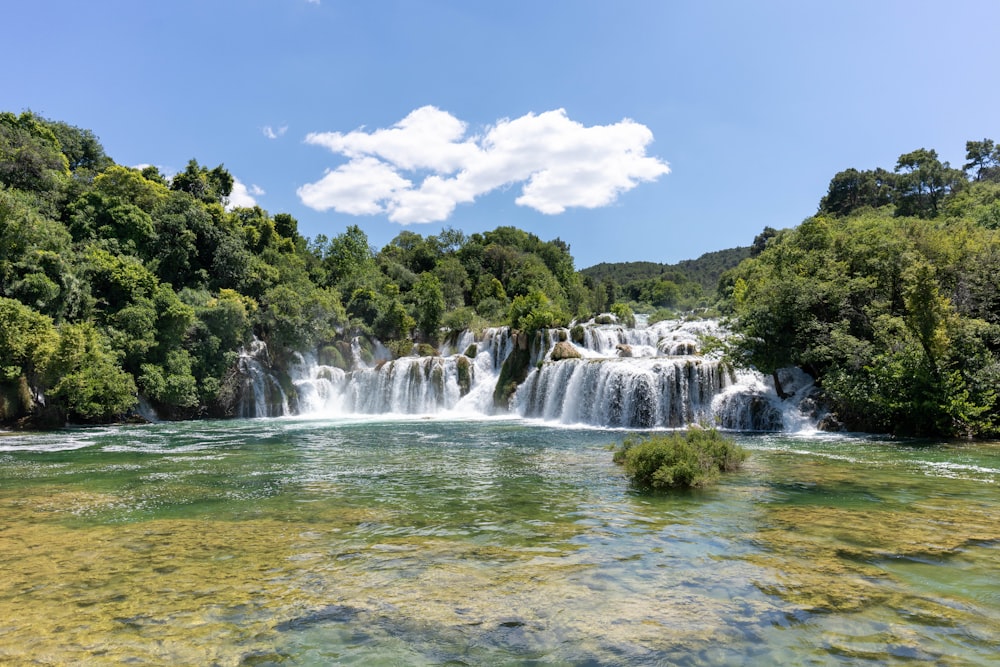 a large waterfall surrounded by lush green trees