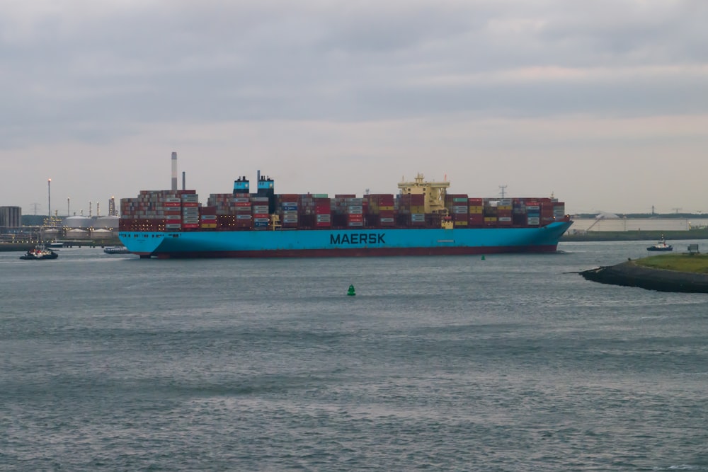 a large blue cargo ship in the middle of a body of water