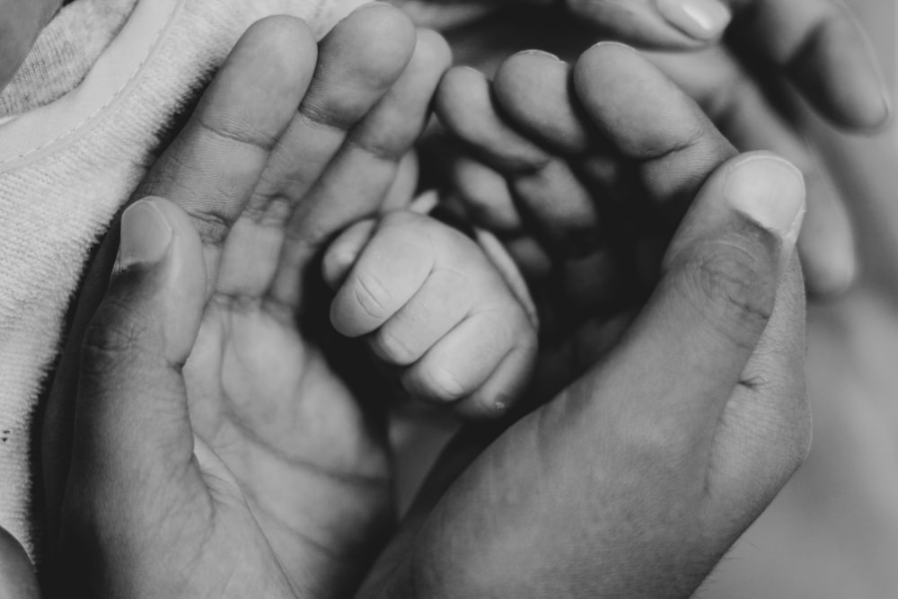 a close up of a person holding a baby