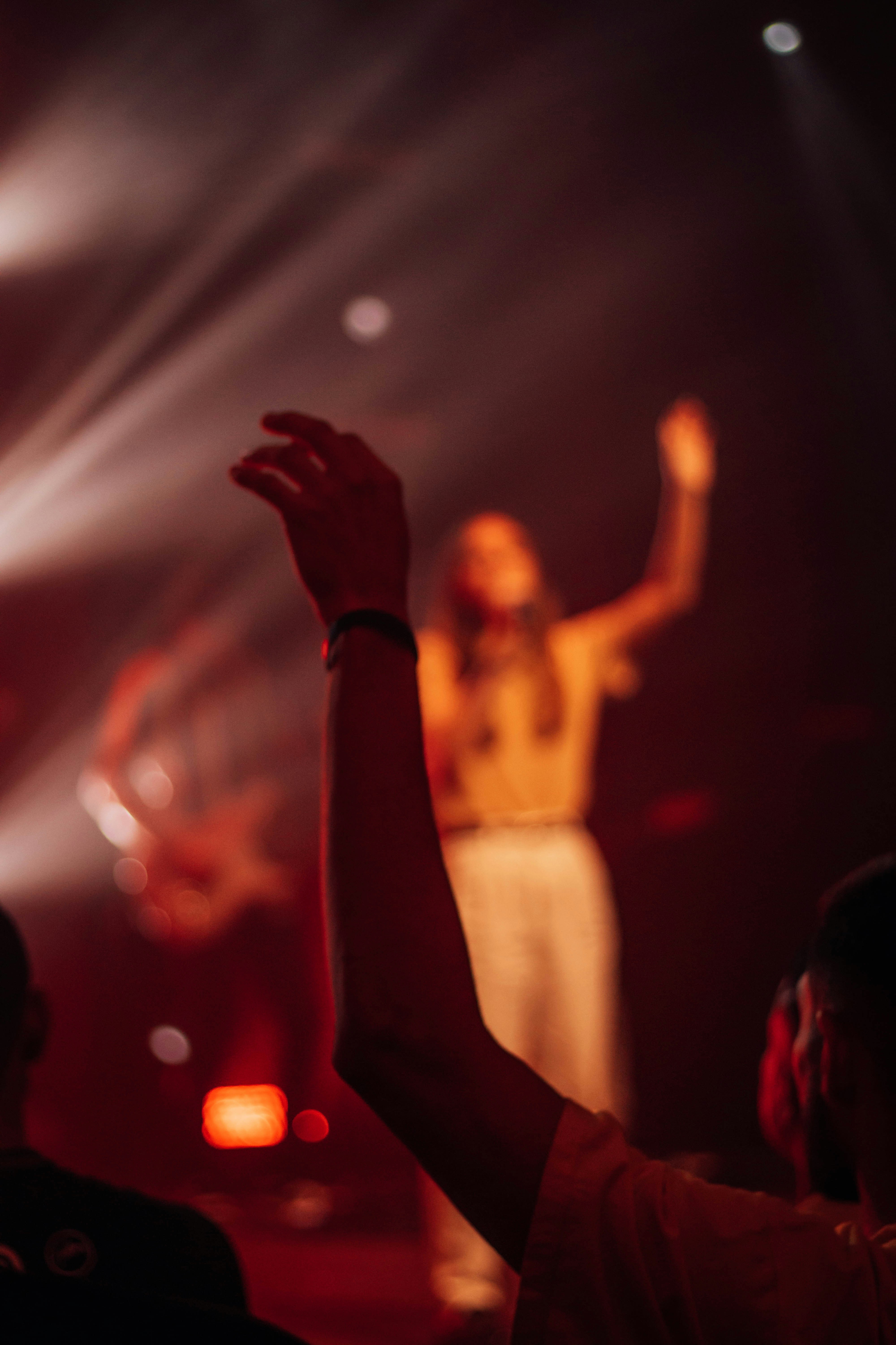 a woman standing on top of a stage holding her hands up