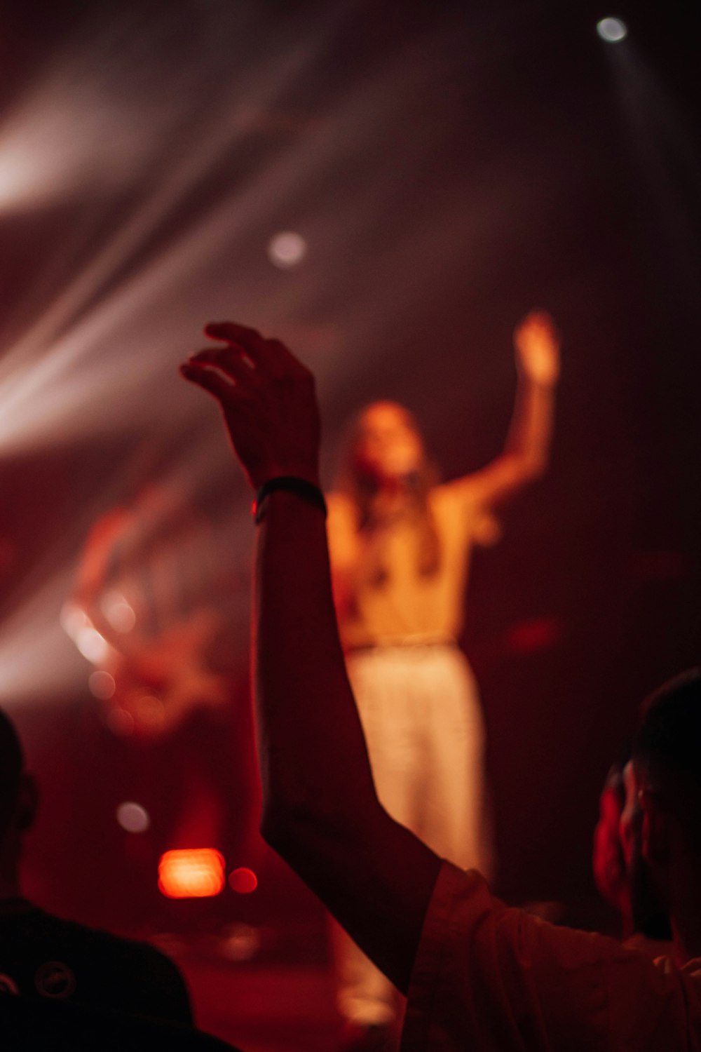 a woman standing on top of a stage holding her hands up