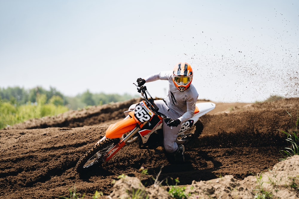 a man riding a dirt bike on top of a dirt field