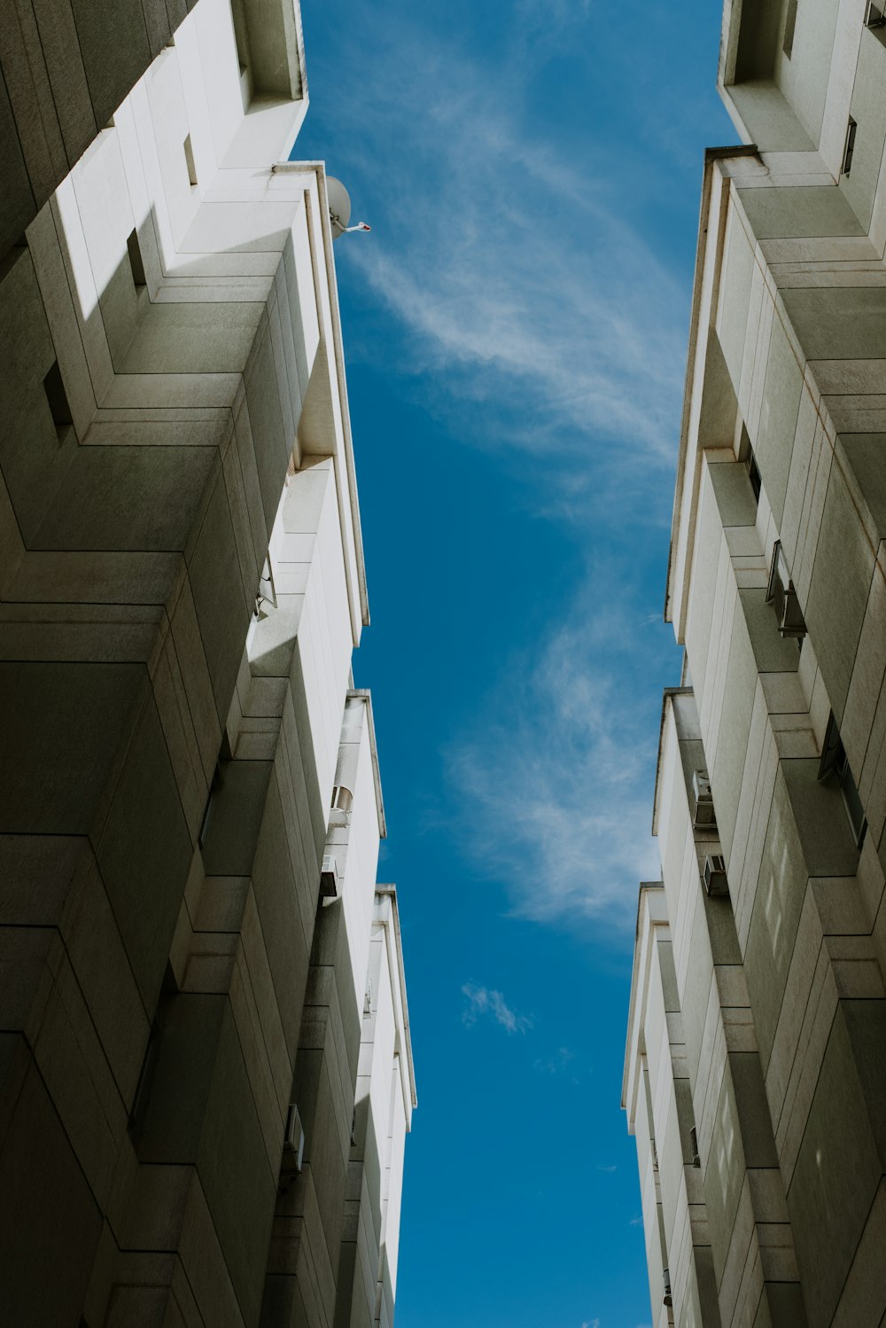 two tall buildings with a blue sky in the background