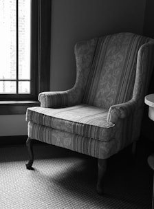 a chair sitting next to a window in a room