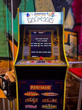 A vibrant vertical arcade machine featuring the iconic Pac-Man game with colorful ghosts chasing the player.