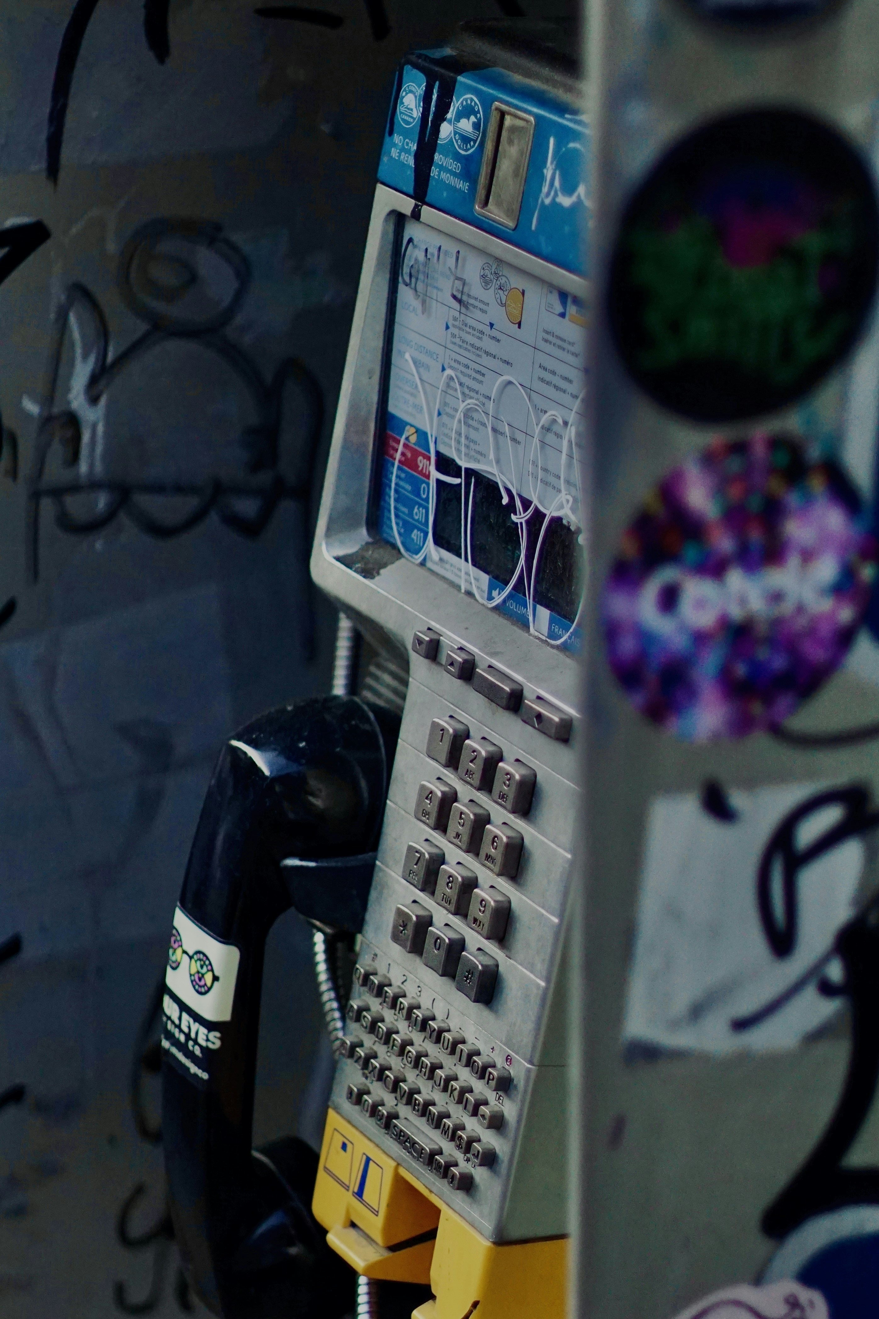 A parking meter sitting next to a wall covered in graffiti photo – Free ...
