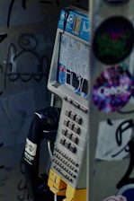A close-up of a vintage prison phone with static and faint prison intercom sounds in the background.