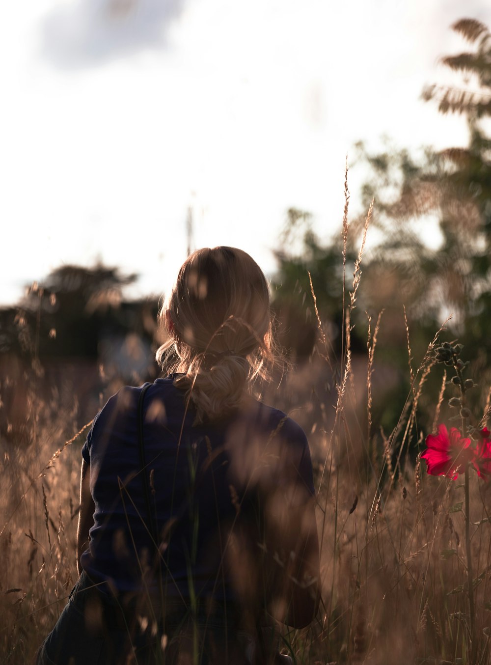 a woman sitting in a field of tall grass