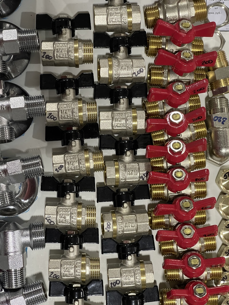 Brass ball valves arranged in a row on white background, clean product photography