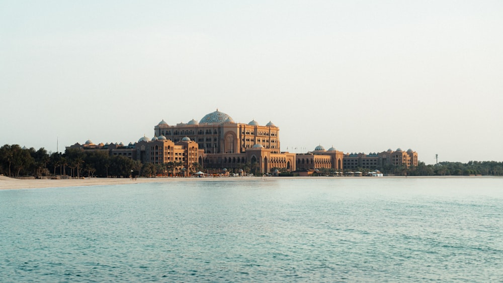 a large building sitting on top of a beach next to a body of water