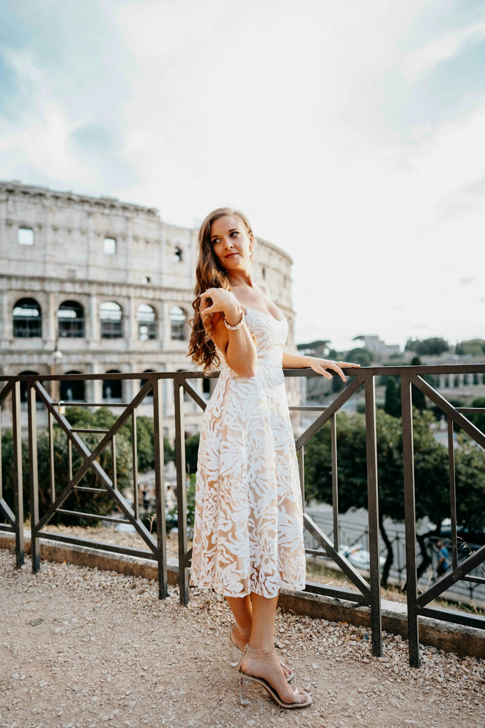 Una mujer con un vestido blanco de pie en un balcón