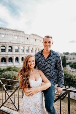 photography poses for couples,how to photograph couple in front of the roman colosseum, rome italy. happy couple, smiling couple, couple holding each other. alecia sanfilippo and alex sanfilippo founder of podpros, podpros.com; a man and a woman standing next to each other