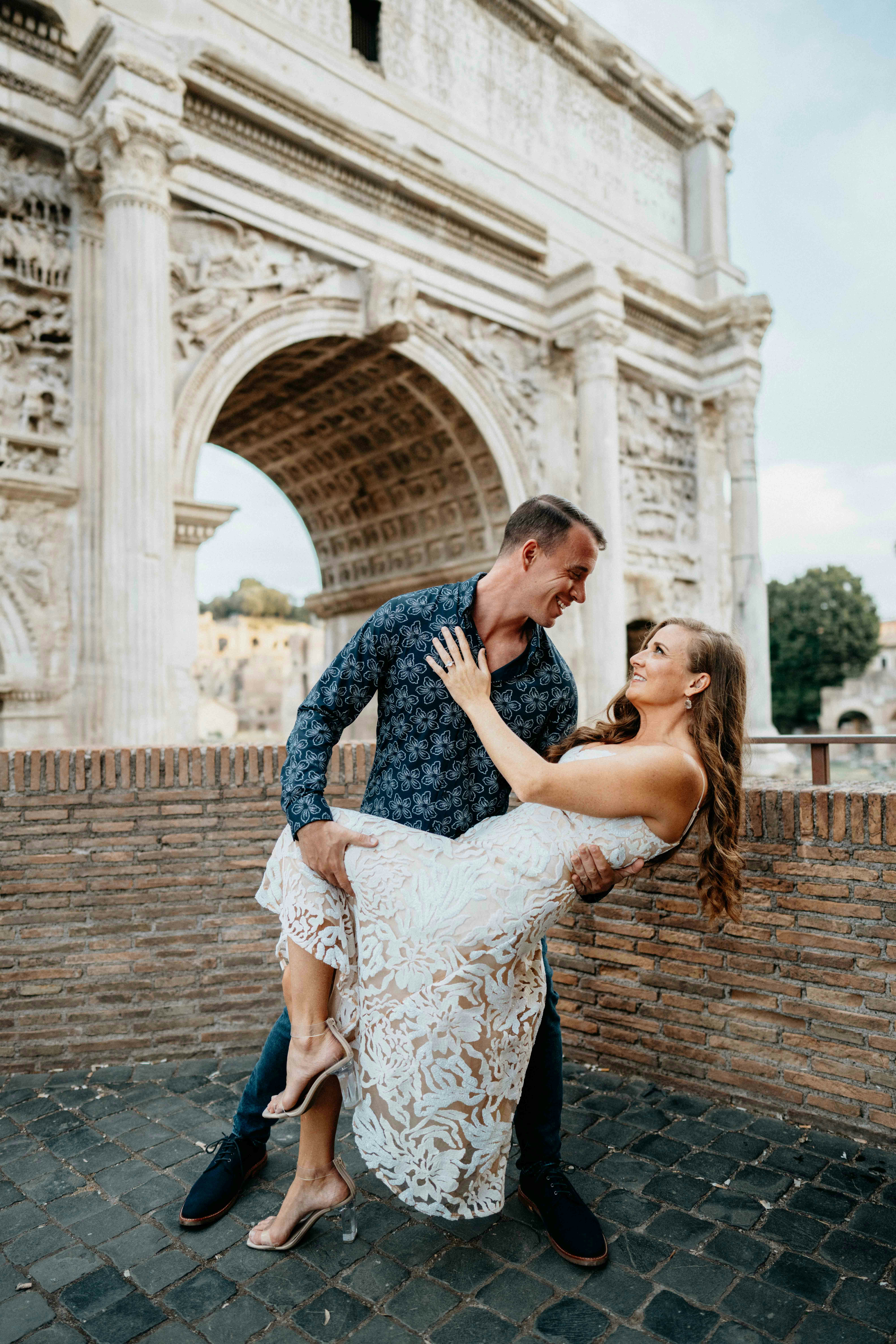 great photo recipe,how to photograph man and woman at the roman forum, dip, dancing couple, dancing, couple in love, looking at each other, alecia sanfilippo and alex sanfilippo founder of podpros, podpros.com; a man holding a woman in front of an arch of triumph