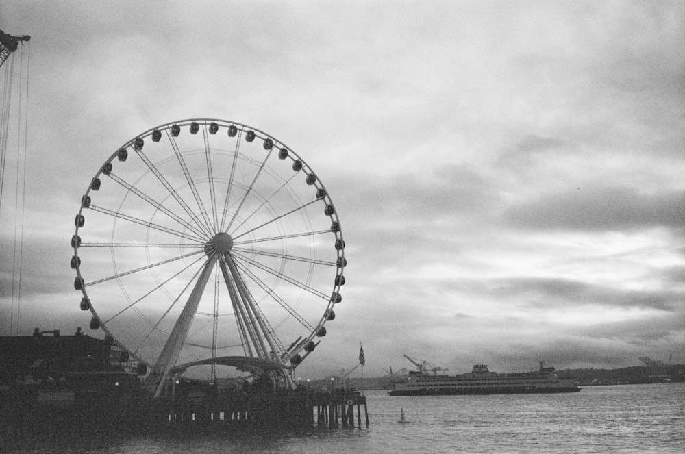 a large ferris wheel sitting next to a body of water