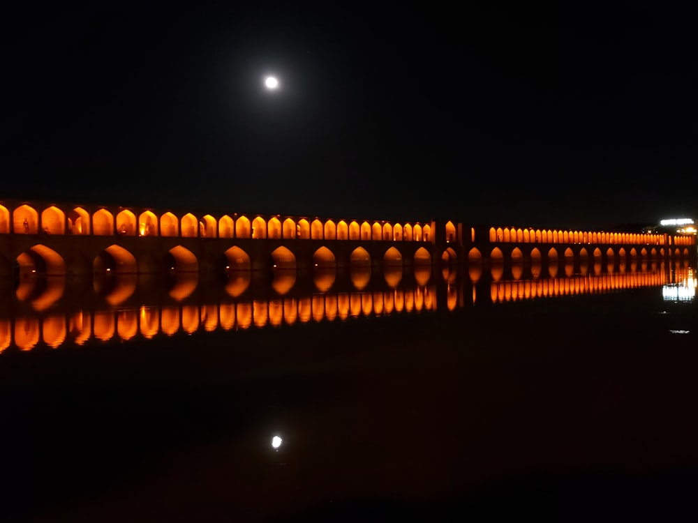 a long wall of orange lights reflecting in the water