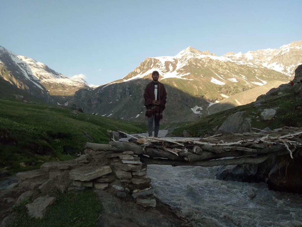 a person standing on a bridge over a stream