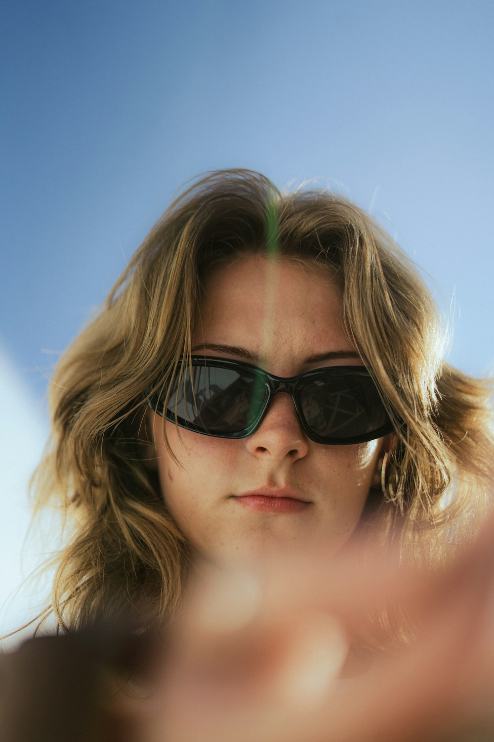 a woman wearing sunglasses looking at her cell phone