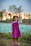 A happy little girl twirling in a colorful dress from the store, smiling outdoors.