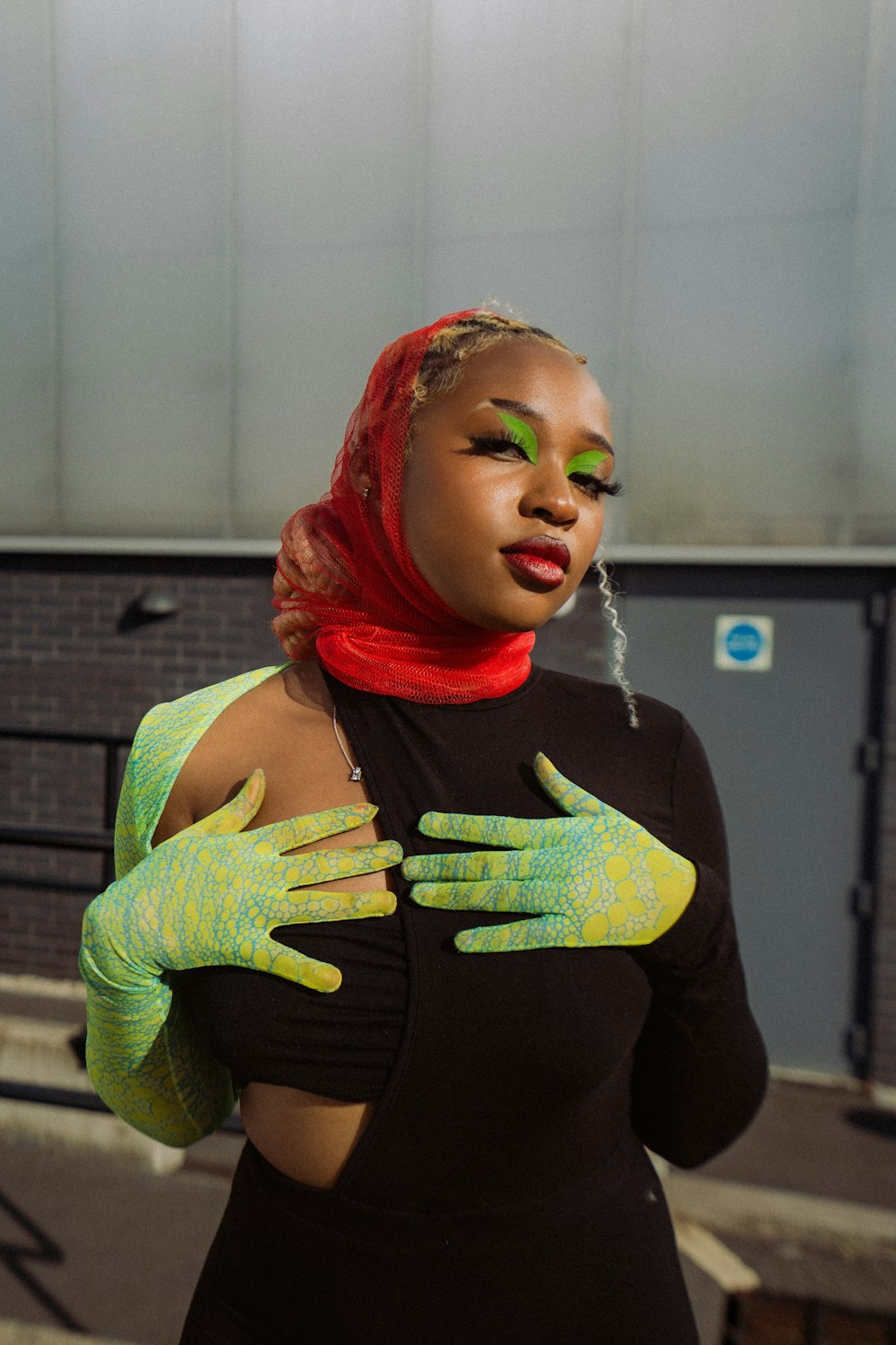 a woman with green and yellow makeup and gloves