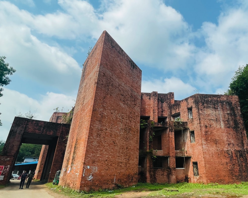 a tall brick building sitting next to a forest