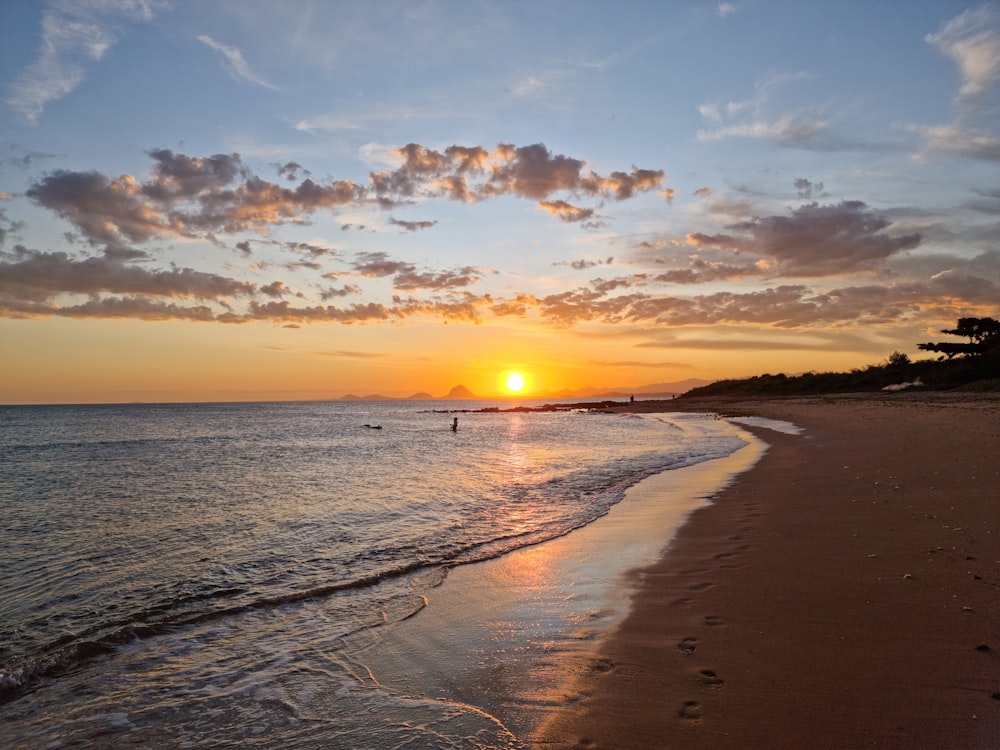 El sol se está poniendo sobre el océano en la playa