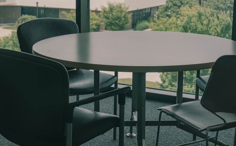 a table and chairs in front of a large window