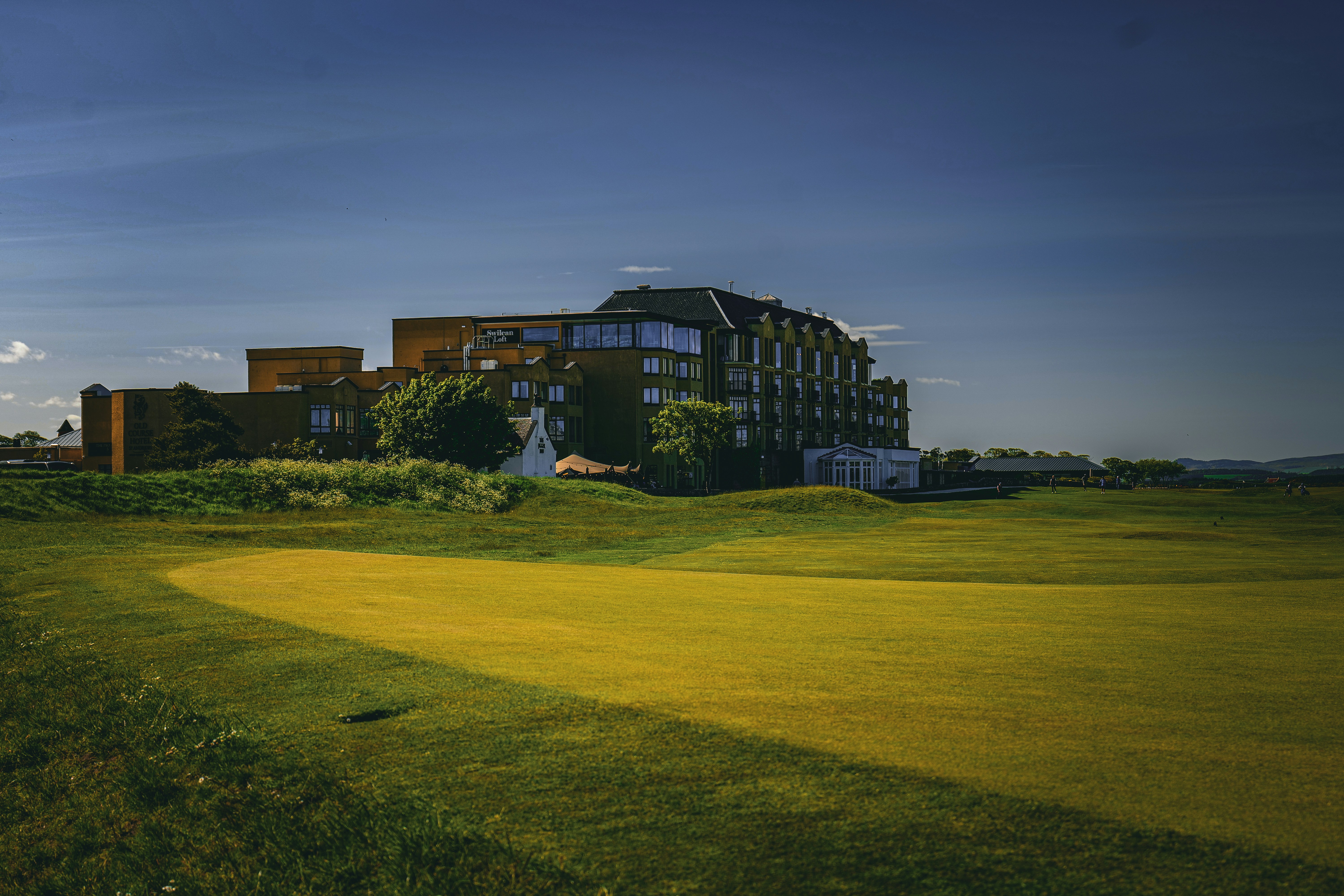 a golf course with a building in the background