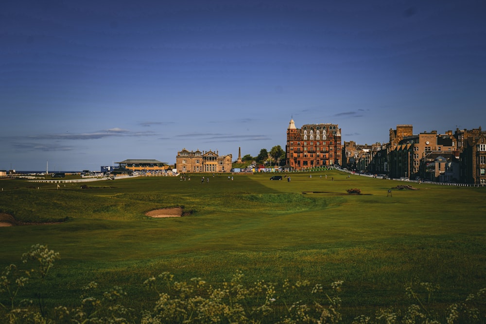 a view of a golf course with buildings in the background