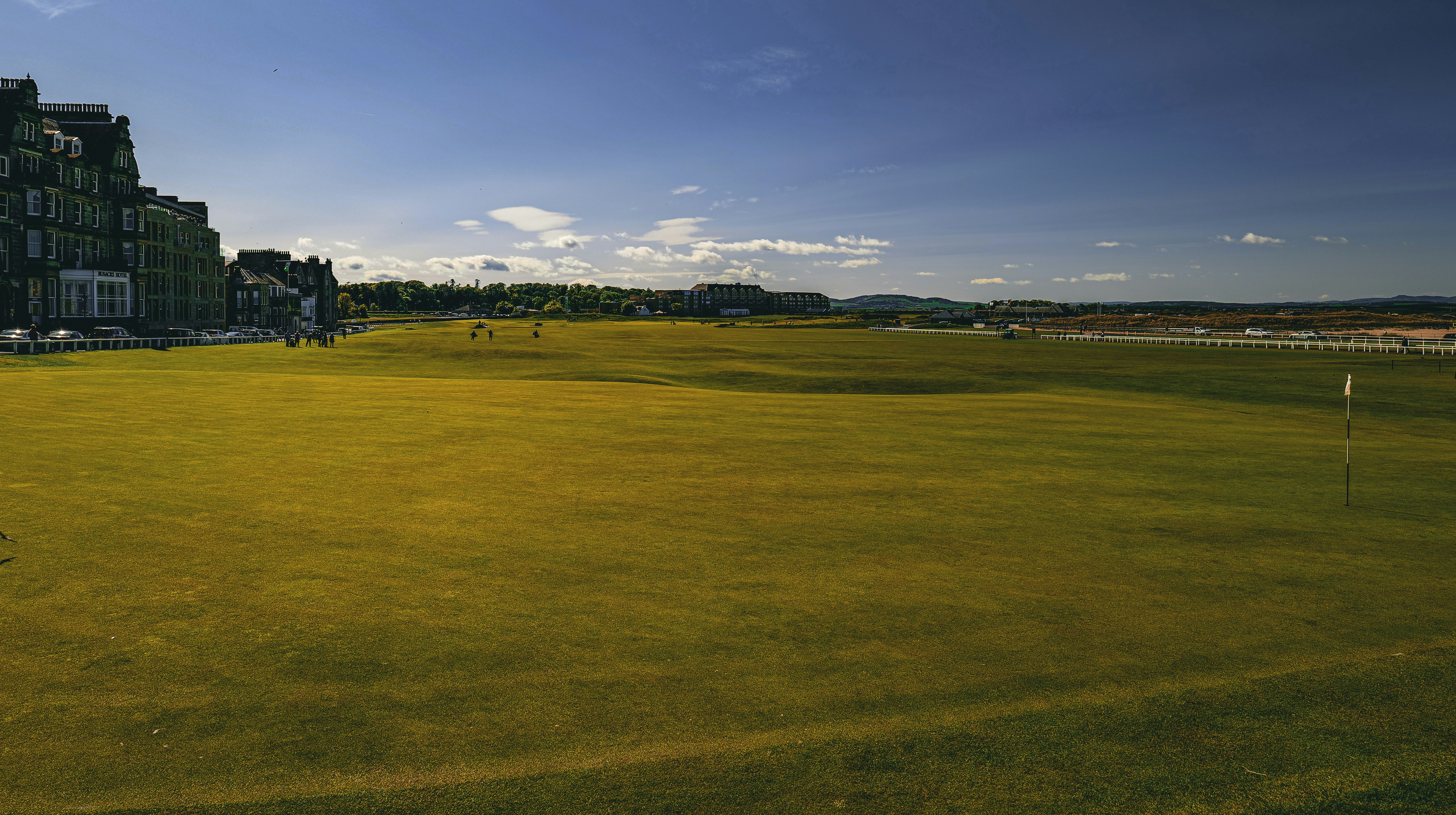 a large grassy field with a building in the background