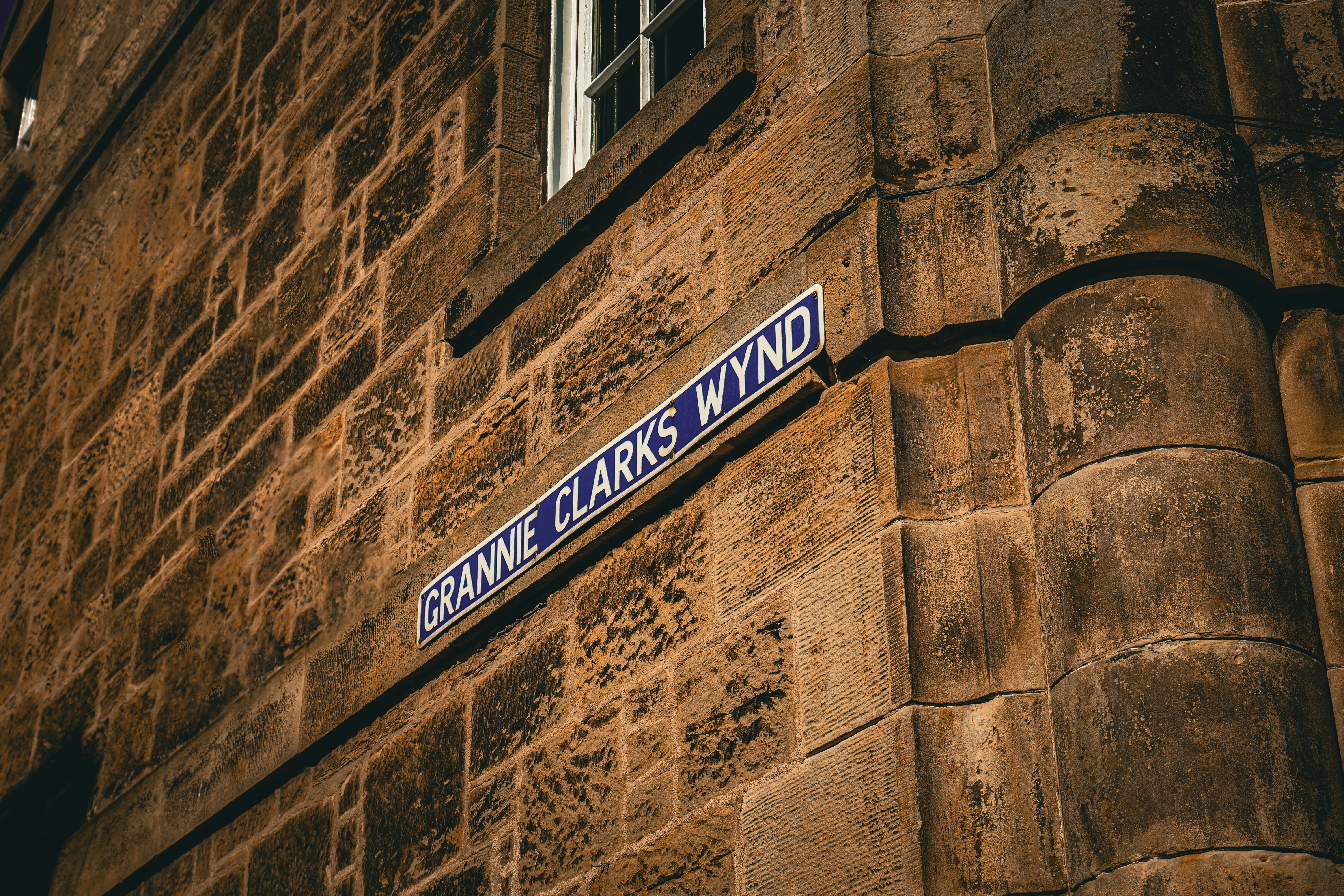 a close up of a street sign on the side of a building