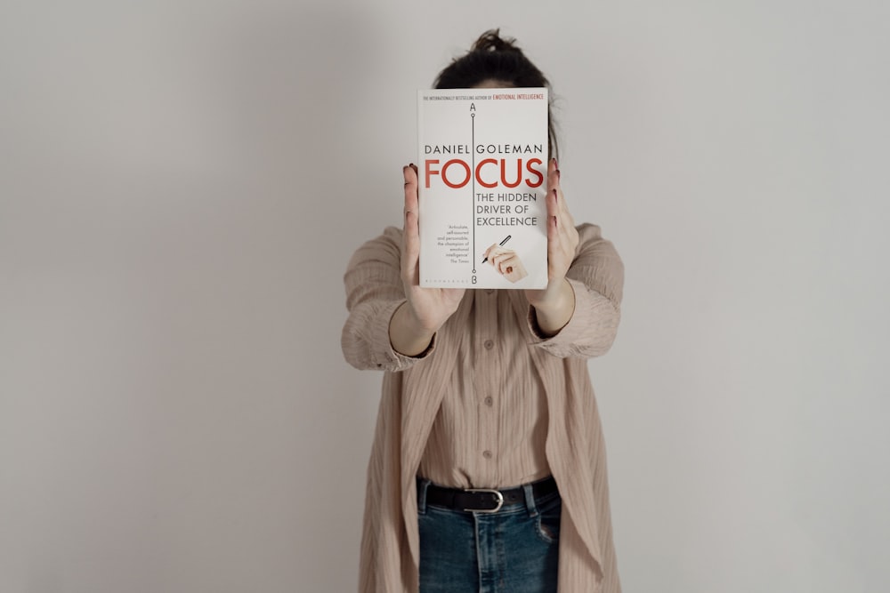 a woman holding up a book to her face