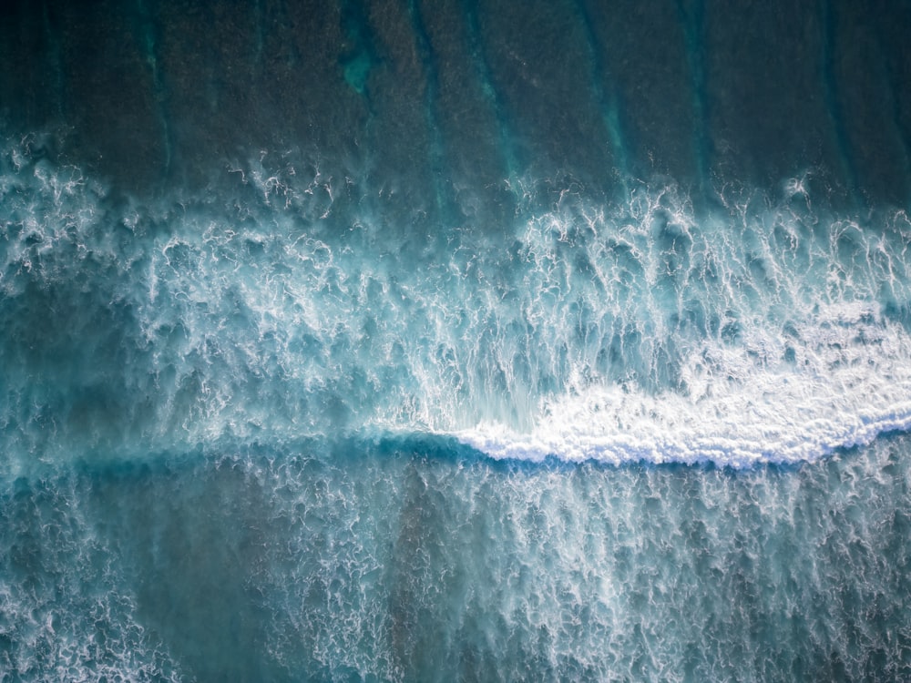an aerial view of a wave breaking on a beach