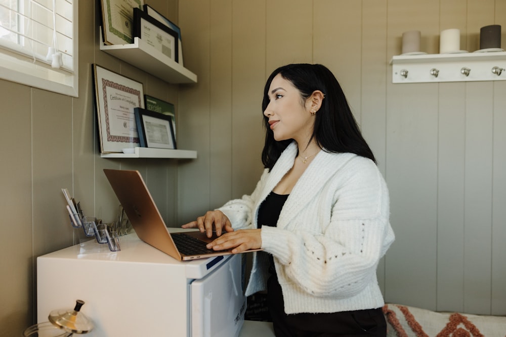 a woman sitting at a desk using a laptop computer