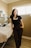 a woman standing next to a bed in a room