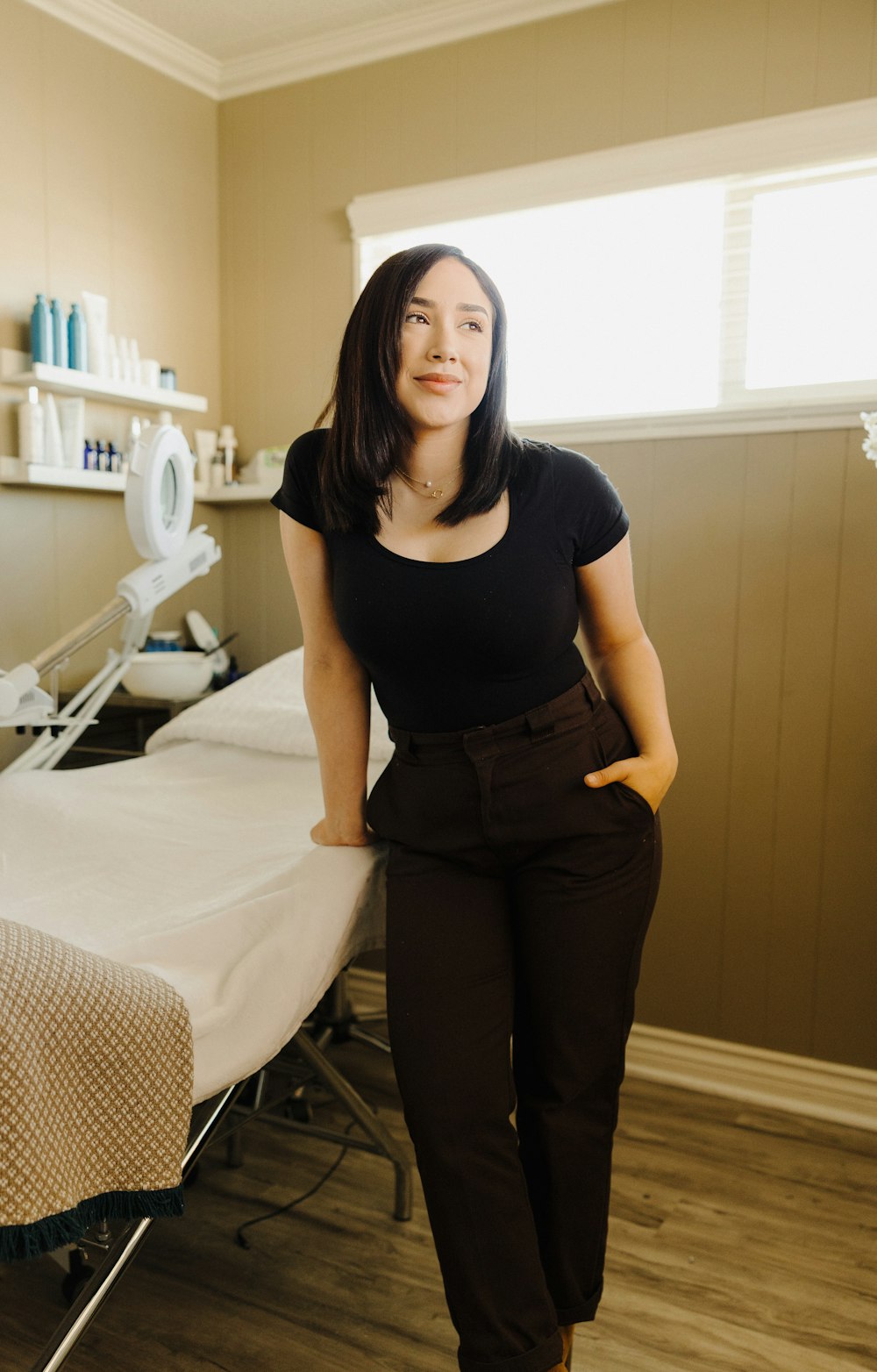 a woman standing next to a bed in a room