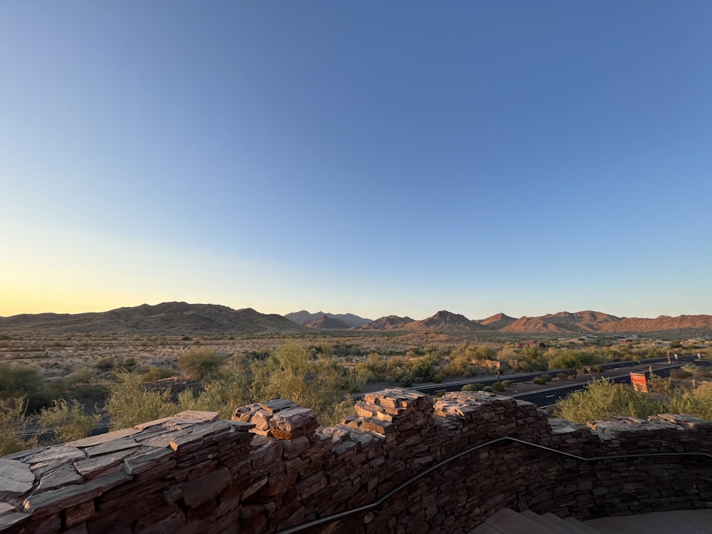 a view of a mountain range from a stone wall