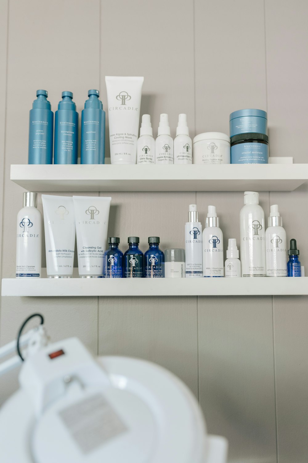 a white shelf filled with lots of different types of skin care products