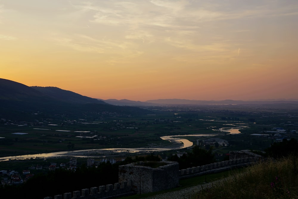 a view of a river and mountains at sunset