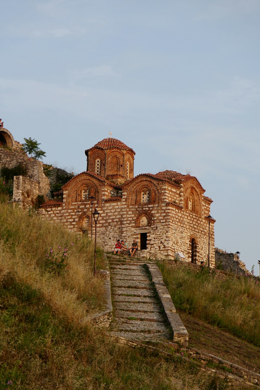 a stone building on a hill with stairs leading up to it