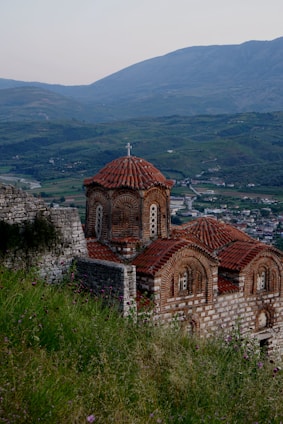 an old church on a hill overlooking a town
